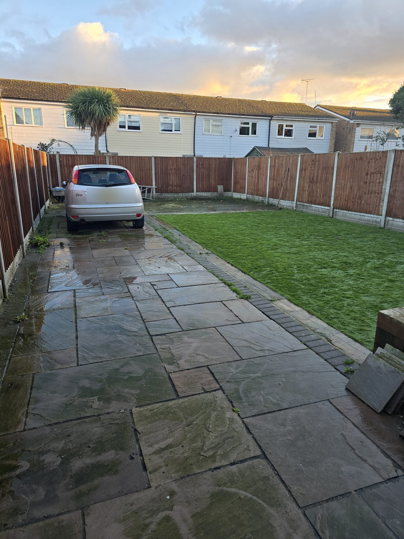 Pressure-washed patio and driveway with artificial grass border